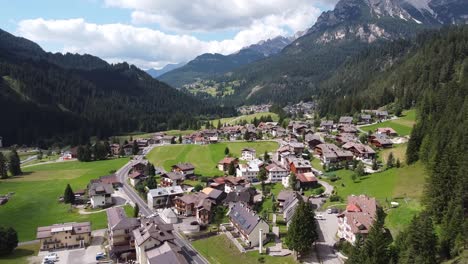 Val-Di-Fassa-Im-Trentino,-Dolomiten,-Italien---Luftdrohnenansicht-Einer-Bergstadt-Im-Grünen-Tal