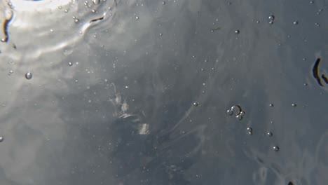 Burbujas-Formadas-En-La-Superficie-Del-Agua-En-Movimiento-En-La-Playa-De-Paralia-Emplisi,-Grecia--Tiro-Estático-Superior