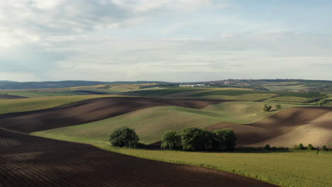 Slow-panoramic-of-rolling-fertile-farming-fields-in-the-rural-Czech-Republic,-aerial-orbit
