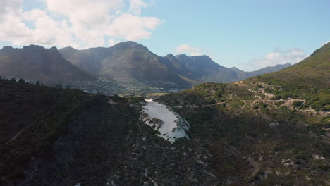 Hout-Bay-Town-With-Mountain-Landscape-In-The-Distance-From-Sandy-Bay,-Cape-Town-In-South-Africa