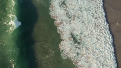 Vertikale-Aufnahme-Von-Schäumenden-Meereswellen,-Die-Mit-Touristen-Am-Strand-Von-Llandudno-In-Kapstadt,-Südafrika,-Zusammenstoßen
