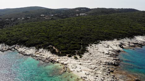 Gorgeous-Stony-Beach-And-Lush-Greenery-Hills-Of-Paralia-Emplisi-in-Erisos-Greece--Aerial-Zoom-in-Shot