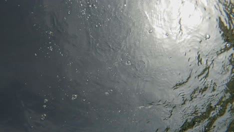 Splash-Creating-Tiny-Bubbles-And-Ripples-On-Water-Surface-Of-Paralia-Emplisi,-Greece-Europe--Static-Shot