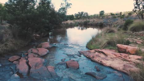 Rocky-ford-over-small-river-in-african-landscape,-forward-dolly-shot