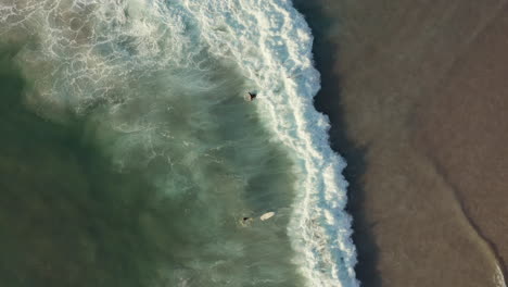 Vista-De-Arriba-Hacia-Abajo-De-Los-Surfistas-En-La-Playa-De-Llandudno,-Ciudad-Del-Cabo,-Sudáfrica---Toma-Aérea-De-Drones