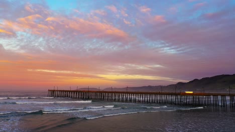 Atemberaubender-Goldener-Sonnenuntergang-über-Dem-Pier-Am-Pismo-Beach---Luftaufnahme-Der-Romantischen-Landschaft
