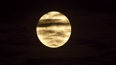 Mesmerising-moonrise-in-dark-night-sky,-clouds-moving-past