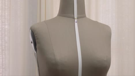 Vertical-panning-shot-of-a-seamstress-mannequin-at-a-fashion-designer's-studio
