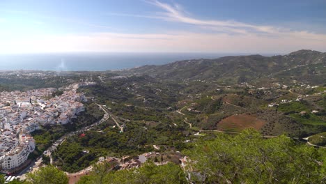 High-above-panorama-view-over-green-countryside-with-white-village-and-ocean