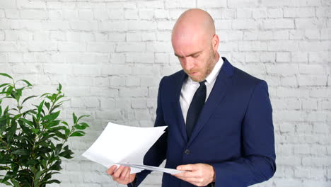 A-businessman-is-upset-after-reading-through-papers-which-he-then-throws-in-the-air