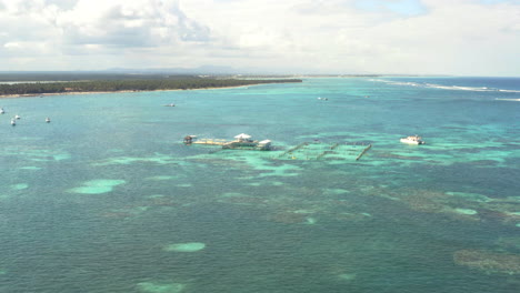 Drone-long-shot-of-dolphin-explorer-sea-attraction,-Punta-Cana-harbor