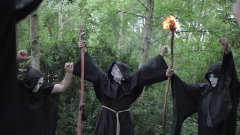 A-cult-meets-in-the-woods-to-perform-a-ritual-chant-and-the-grand-master-raises-his-hands-with-a-magical-staff
