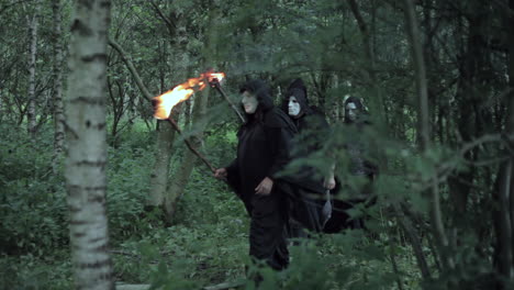 An-unrecognizable-man-hides-from-a-cult-of-evil-hooded-druids-in-the-woods-who-are-about-to-perform-a-sacrifice-ritual