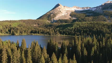 Drone-Flying-Over-Pine-Trees-Revealing-Lake-Near-Kebler-Pass-Mountains-In-Colorado-USA