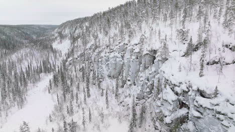 View-At-The-Side-Of-Korouoma-Canyon-With-Pine-Trees-And-Frozen-Waterfalls-In-Lapland,-Finland---Aerial