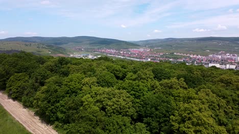 Drone-view-over-Hoia-Baciu-forest-and-Baciu-village-in-the-distance,-near-Cluj-Napoca-city-in-Romania