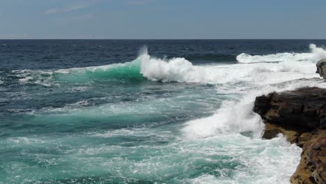 Waves-breaking-on-rocky-cliff-near-Bondi-Beach,-Australia