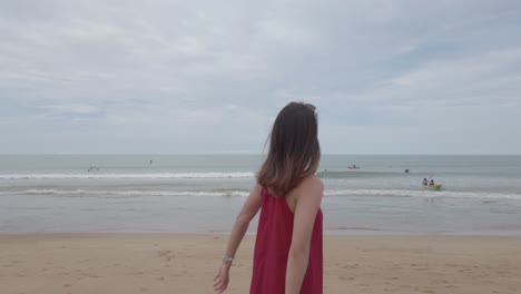 Junge-Asiatische-Frau-Trägt-Rotes-Kleid-Und-Geht-Entspannt-Am-Strand-In-Den-Sommerferien-In-Slowmotion