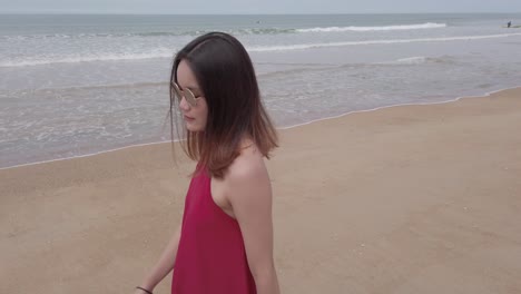 Young-asian-woman-wear-red-dress-and-walking-relaxing-on-the-beach-at-summer-vacation-holidays-in-slowmotion