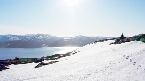 Schneebedeckte-Berge-Mit-Hellem-Sonnenlicht,-Das-Sich-Im-Fjord-Bei-Blaheia,-Norwegen,-Widerspiegelt