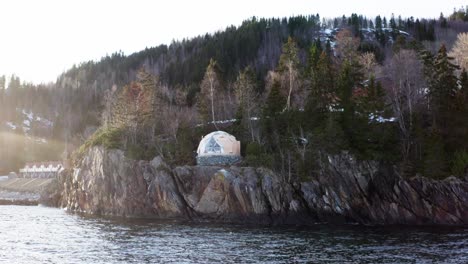 Arctic-Dome-Tent-Atop-On-Rocky-Cliff-Ocean-At-Sunrise-In-Norway