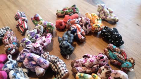Handmade-colourful-unique-adorable-miniature-patterned-toy-teddy-bears-dropped-onto-wooden-table