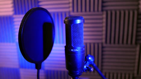 A-professional-studio-condenser-microphone-in-a-recording-voice-over-vocal-booth-on-a-stand-with-pop-sheild