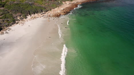 Aerial-view-of-Sandy-beach-in-Llandudno,-nude-beach,-South-Africa---pullback-shot
