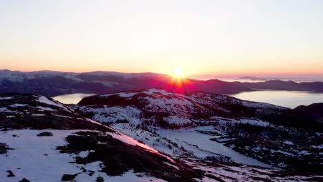 Sonnenuntergang-In-Den-Schneebedeckten-Bergen-Und-See-Mit-Sonnenstrahlen-In-Blaheia,-Norwegen