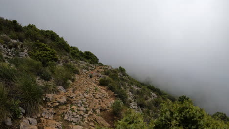 4k-Static-shot-of-a-rocky-path-on-a-mountain-in-a-thick-fog-clouds-at-La-Concha,-Marbella,-Spain