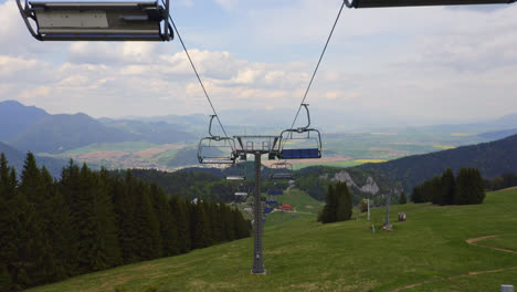 Empty-chair-lifts-travelling-along-the-mountainside-in-Malino-Brdo-located-in-Ružomberok,-Liptov,-Slovakia