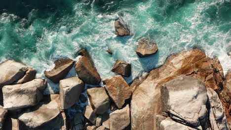 Sea-Waves-Splashing-On-Huge-Stones-At-Oudekraal-Beach,-Cape-Town,-South-Africa---aerial-top-down