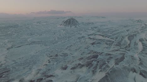 Friedliche-Islandlandschaft-Mit-Schneebedeckten-Berggipfeln-Bei-Sonnenuntergang---Luftschwenkansicht