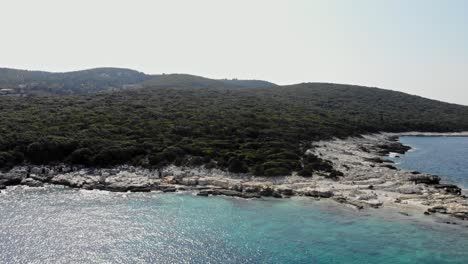 Rocky-Coast-And-Lush-Vegetation-At-Paralia-Emplisi-Beach-In-Greece---aerial-drone-shot