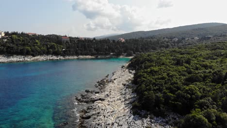 Ruhige-Ansicht-Des-Emplisi-strandes-Mit-Fiskardo-stadt-Im-Hintergrund-In-Kefalonia,-Ionische-Inseln,-Griechenland