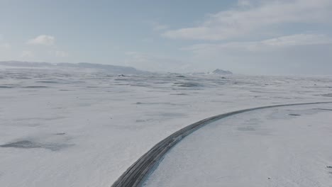 Road-Traveling-through-Frozen-Snowy-Tundra-of-Iceland---Aerial