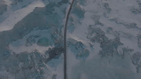Cars-Traveling-on-Highway-Road-through-Snowy-Iceland-Countryside---Aerial-Bird's-Eye-Top-Down-View