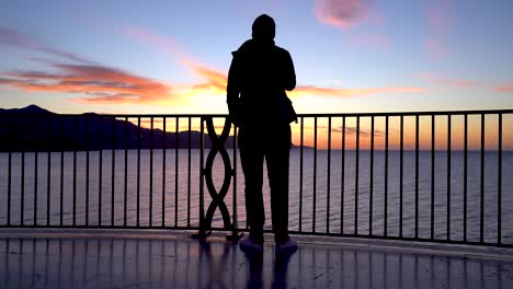 Silhouette-Eines-Mannes,-Der-Bei-Sonnenaufgang-Vom-Aussichtspunkt-Aus-Auf-Das-Schöne-Meer-Blickt