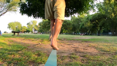 Slow-motion-of-man-balancing-on-one-foot-at-wooden-slack-line