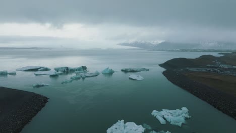 Floating-Icebergs-in-Cold,-Dreary-Ocean-Landscape-of-Iceland---Aerial