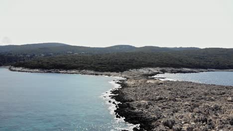 Strand-Mit-Felsiger-Küste-Und-üppiger-Vegetation-Bei-Paralia-Emplisi-In-Griechenland---Luftdrohnenaufnahme