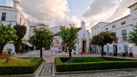 4K-Aufnahme-Eines-öffentlichen-Parks-Mit-Weißen-Häusern-Und-Orangenbäumen-In-Marbella,-Spanien