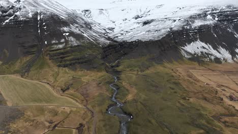 River-Flowing-from-Snowy-Mountains-in-Gorgeous-Iceland-Landscape,-Aerial
