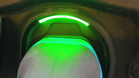 Green-light-lighting-during-charging-process-of-plugged-electrical-car,close-up