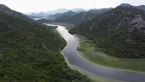 Boat-Sails-over-Crnojevica-River-to-Skadar-Lake-at-Pavlova-Strana-Viewpoint,-Montenegro---Aerial-Dolly