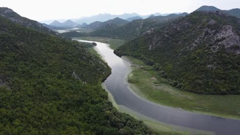 Boat-Slowly-Sails-over-Crnojevica-River-to-Skadar-Lake-at-Pavlova-Strana-Viewpoint,-Montenegro---Aerial-Dolly