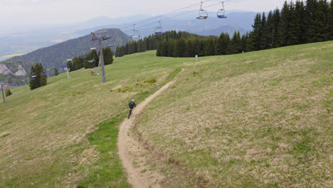 Young-Boy-Biking-Through-Grassy-Hillside-In-Summer-At-Malino-Brdo-Resort,-Liptov,-Slovakia