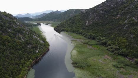 Boot-Segelt-über-Den-Crnojevica-Fluss-Zum-Skadar-See-Am-Aussichtspunkt-Pavlova-Strana,-Montenegro---Langsame-Antenne