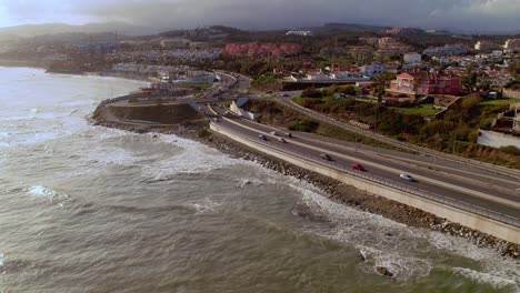Drone-tilting-up-to-the-residential-coastline-of-Mijas-Costa-after-a-storm