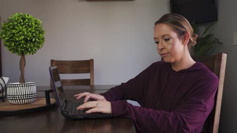 Mujer-Seria-Escribiendo-En-Su-Laptop-Trabajando-En-Casa